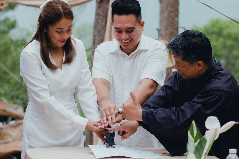 Un couple finalisant les formalités de mariage avec l'officiant en extérieur