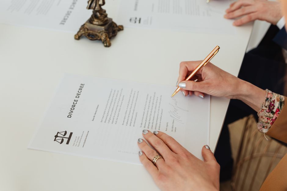 Hands signing an official document representing a Vietnamese power of attorney notarization